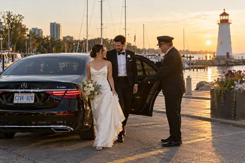 Chauffeur holding the door for a bride and groom at the Port Credit lighthouse