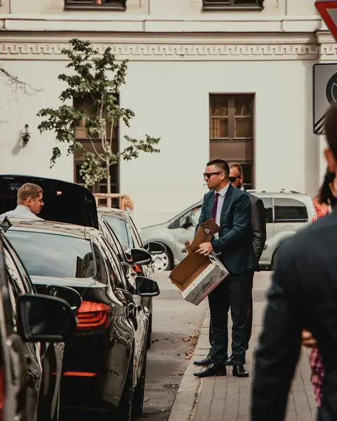 Business travellers beside a line of black cars