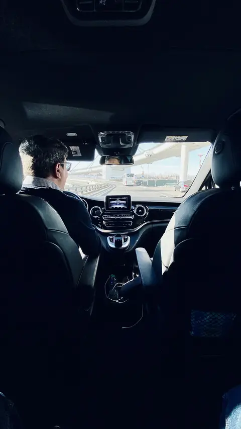Chauffeur at the wheel, seen from the rear seat