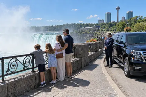 Family at the Horseshoe Falls with their chauffeur and SUV